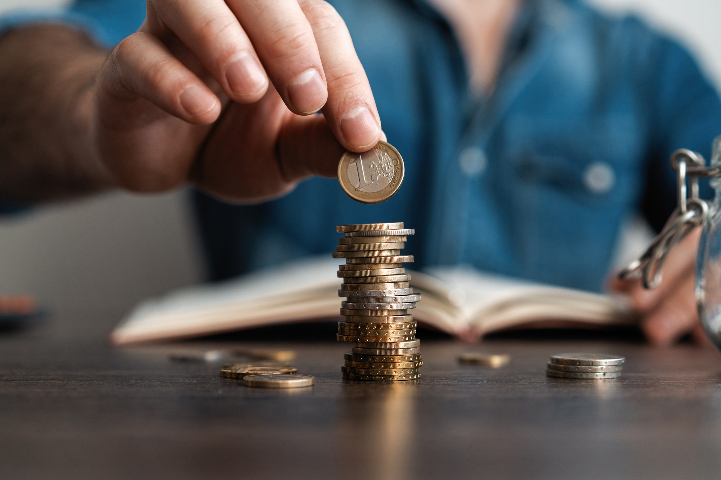 Business man putting a coin on coins stack saving bank and account for his money all in finance accounting concept